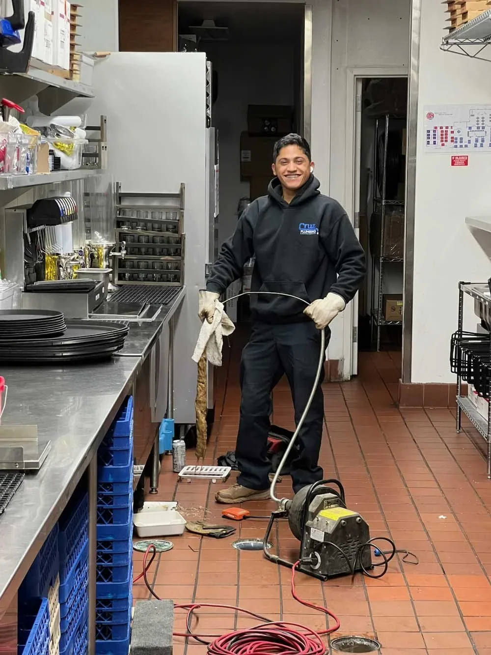 Cruz technician with drain cleaning equipment in a commercial kitchen