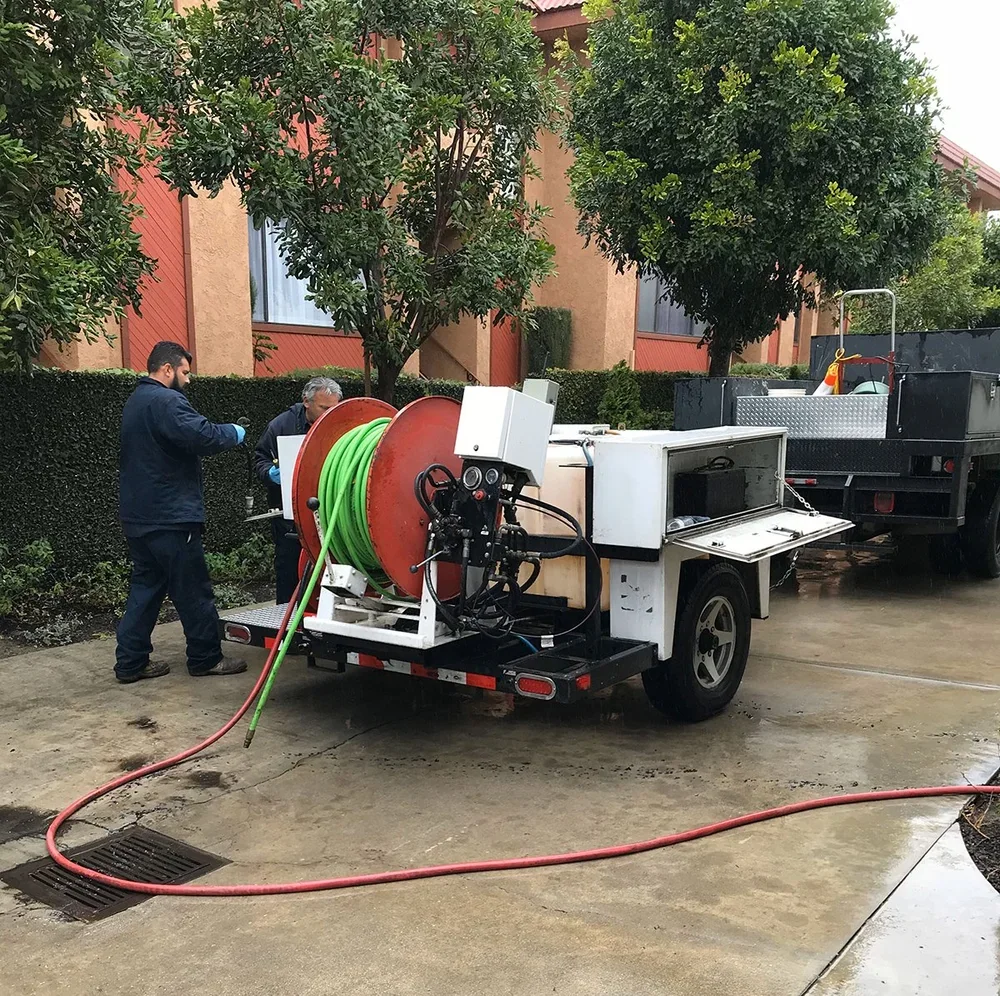 Cruz technicians beside hydrojetting equipment on a service vehicle