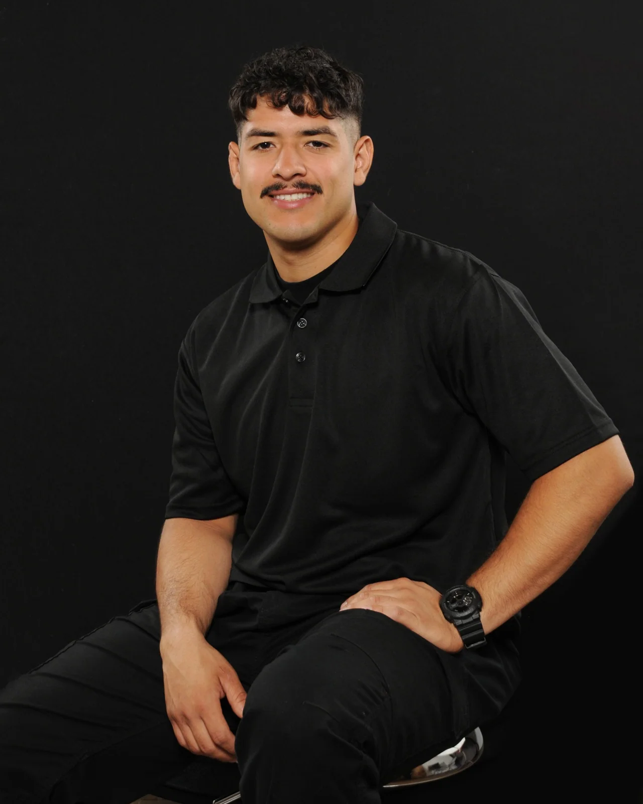 Cruz Plumbing team member wearing a black company polo against a dark background